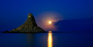 mountain island near body of water during night time HD wallpaper