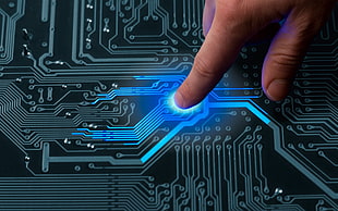 person touching black circuit board with emitting blue LED light