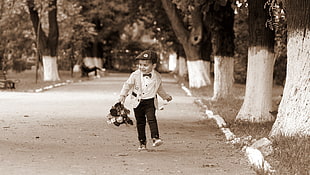 boy wearing white 2-blazer walking next to trees