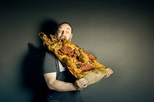 man eating large pizza slice