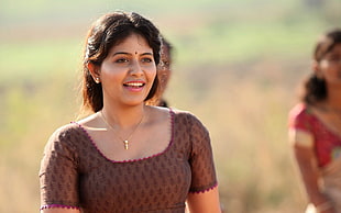 woman in brown choli blouse smiling