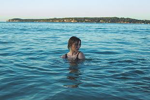 female swimming on body of water during daytime HD wallpaper