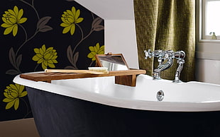 white and black metal bathtub with faucet