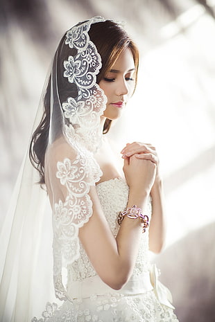 woman wearing white sweetheart neckline wedding gown with veil