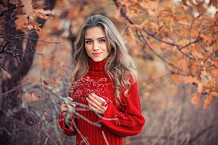 woman wearing red sweater standing near tree landscape photograph