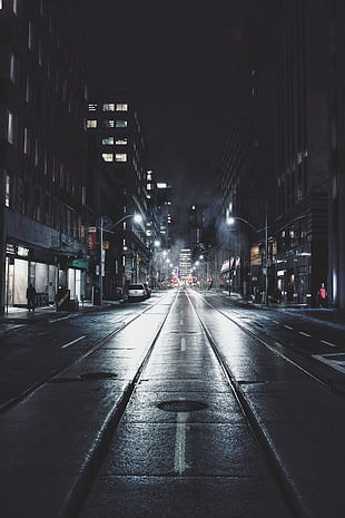 person walker near buildings during nighttime HD wallpaper