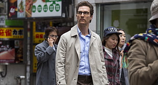 man wearing brown coat walking on the street