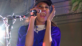 woman wearing blue dress holding black microphone