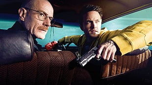 two men sitting on car holding gun