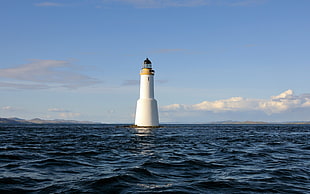 white lighthouse in the middle of the sea