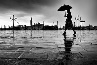 silhouette of a girl walking in park holding umbrella, venice