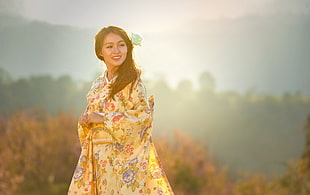 focus photography of woman wearing yellow floral traditional dress during daytime