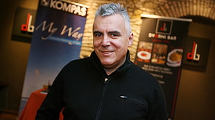 man smiling while wearing black zip-up top HD wallpaper