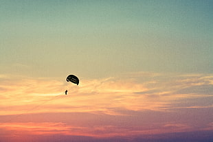 person playing parasailing during dusk