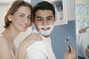 man with shaving foam with woman with blonde hair smiling