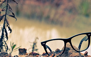 black framed eyeglasses on top of rocks