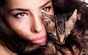 closeup view of woman's face and brown tabby cat