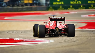 red F1 car running on race track during daytime