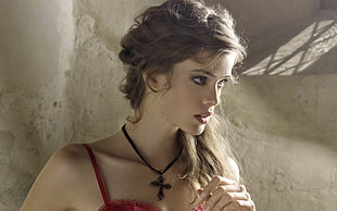 brown haired woman in red spaghetti-strap top wearing black crucifix necklace