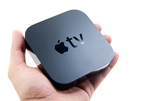 person holding Apple TV HD wallpaper