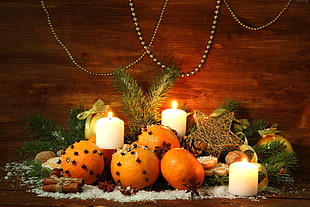 oranges, pillar candles, and star decoration on brown wooden table