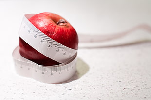selective focus photography of apple wrapped by measuring tape