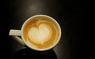 liquid filled white ceramic cup with heart artwork