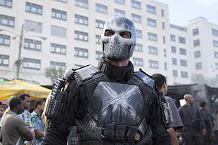 man wearing gray mask and armored vest during daytime