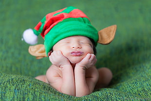 selective focus photography of baby wearing elf hat