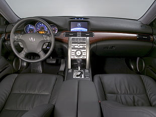 black Acura car steering wheel with grey center console and black dashboard