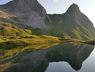gray and green mountains near body of water