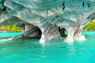 body of water under gray rock formation