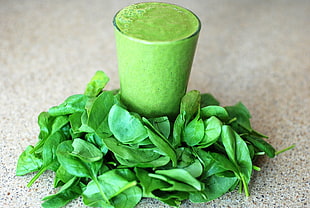 green mint leaves beside full-filled drinking glass