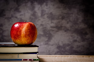 red and yellow apple on books HD wallpaper