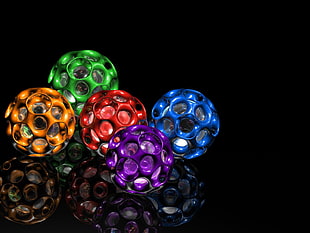 five assorted ball toys on black surface