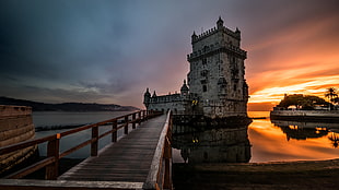 close up photo of bridge headed to the gray castle with a sunrise view, lisbon, portugal