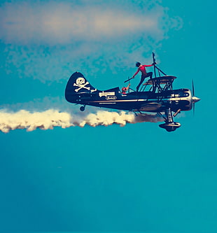 time lapse photography of person standing on biplane, airplane, sky show, smoke, war