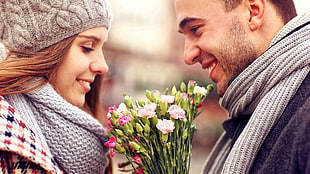 shallow focus photography of woman and man holding flower bouquet