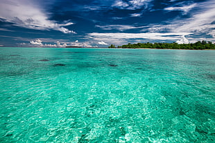 landscape photography of island and teal body of water