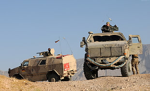 two brown-and-beige battle trucks in daytime photo