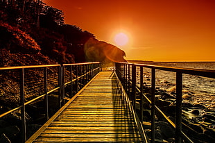 bridge beside of ocean during sunset HD wallpaper