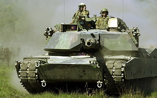 soldiers on a tank during day time