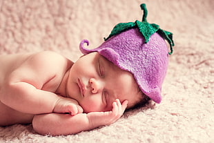 baby wearing purple flower hat