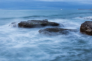 photo of sea wave with rocks during daytime HD wallpaper
