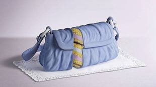 blue clutch bag on white textile