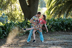 man and woman dancing under tree during daytime