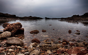 brown rocks on a body of water during day time HD wallpaper