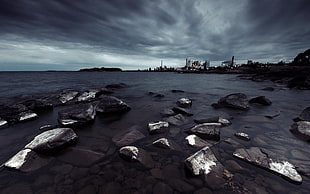 rocky shore under cloudy sky during daytime HD wallpaper