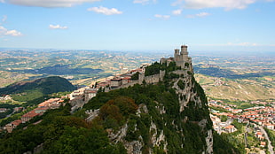 gray concrete castle on top of mountain, nature, bird's eye view, village, castle