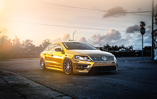 gold-colored Volkswagen Jetta on gray concrete road at daytime HD wallpaper